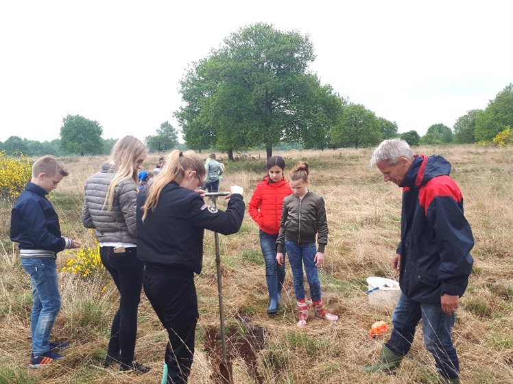 Een van de docenten met enkele leerlingen aan het boren (foto: Bart Koops).