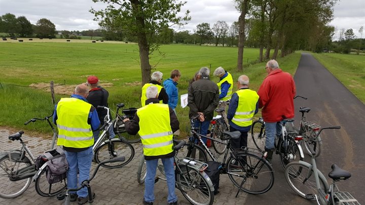 Figuur 1. Tijdens de excursie krijgt men uitleg van Anja Verbers. Links op de foto zie je de laagte in het grasland. Deze locatie is zeer waarschijnlijk een pingoruïne (nr. 285)! (foto: Arne van Liere).